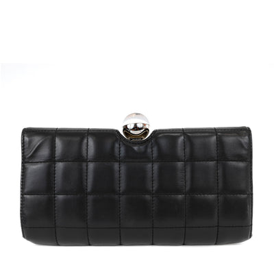 This Chanel clutch is a true statement piece, blending classic black and white lambskin leather with a chic square-stitching pattern